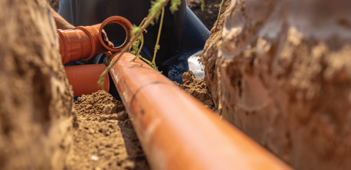 An empty drain pipe lies in an excavated trench in Ashford.