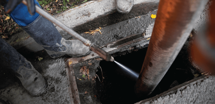 A professional drain technician uses a jetting hose to clear a gully drain in Rochester.
