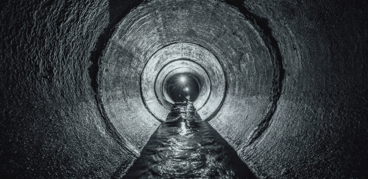 The interior of a sewer drain with water flowing through it in Rochester.