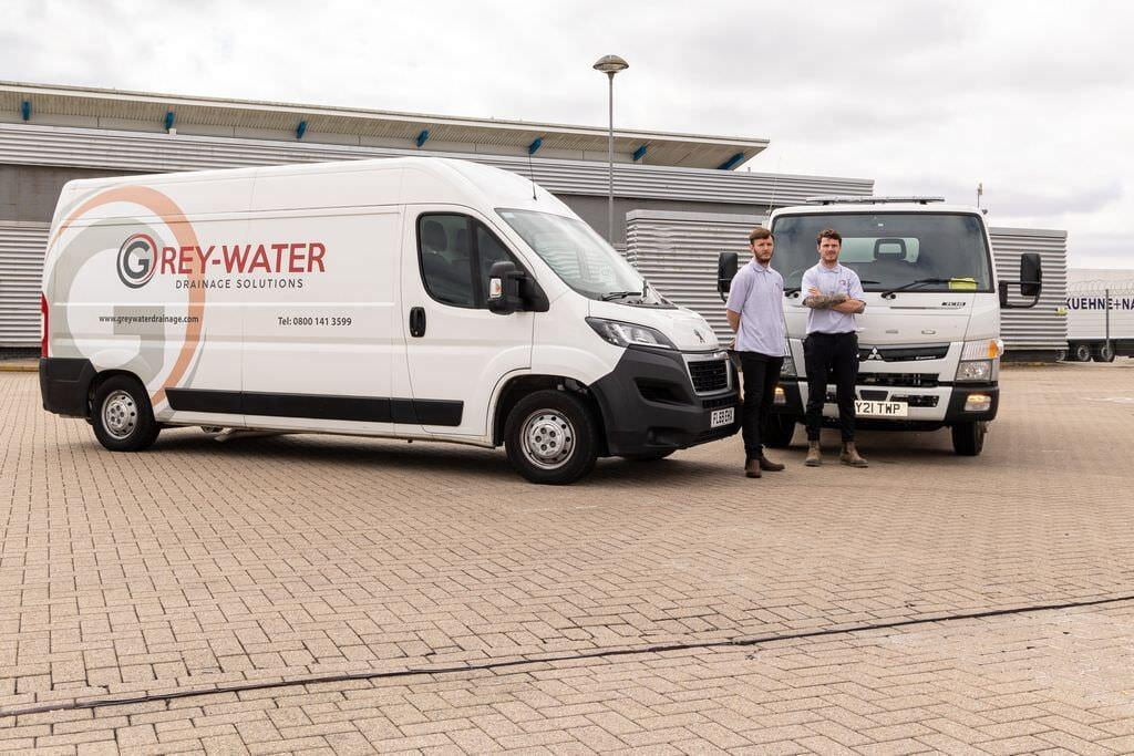 Chris and James stand in front of the Grey-Water vans parked in Medway.