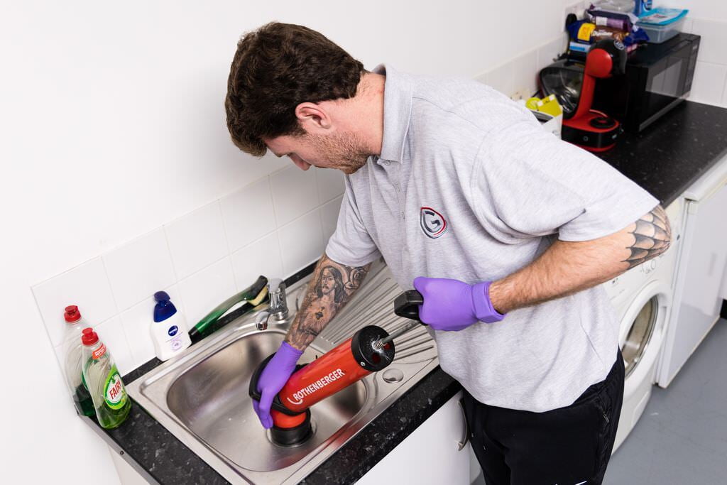 James uses a plunger to unblock a sink in Tunbridge Wells.