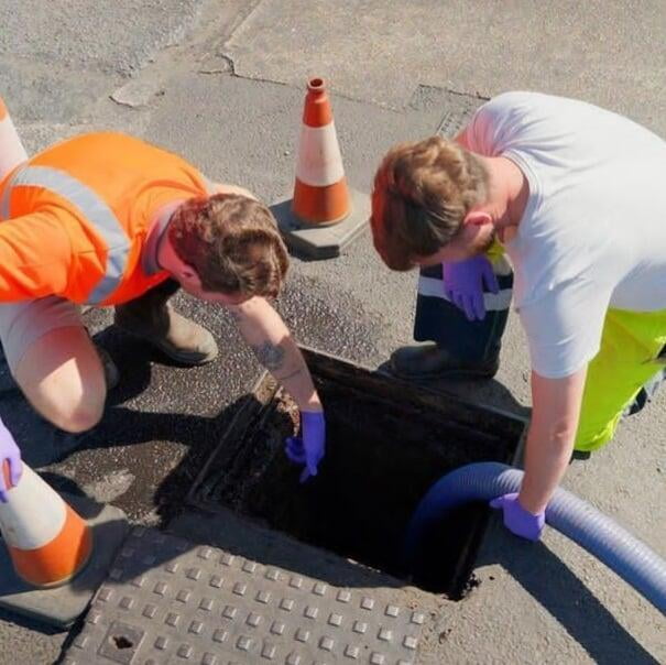 Chris and James unblocking a manhole drain.