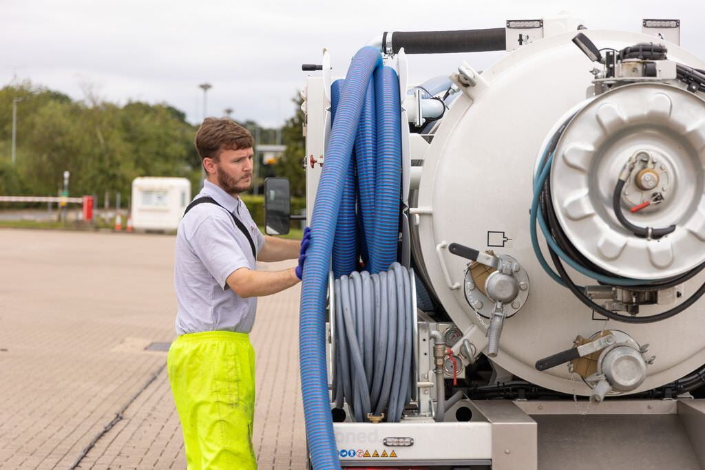 Chris prepares a large suction hose to clear a manhole in Bromley.