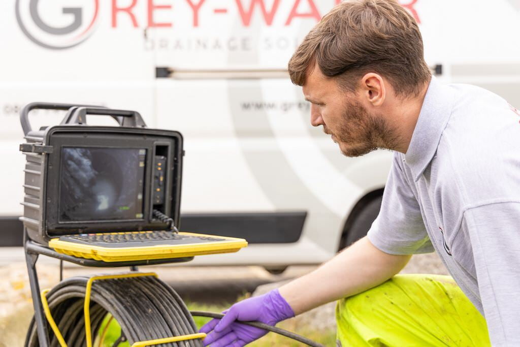 Chris looks to the live CCTV drain footage of the manhole he's inspecting in Lewisham.