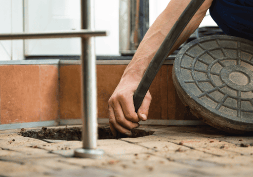 Use of a drain rod to unblock an open manhole.