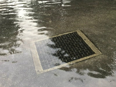 A storm drain is submerged in deep water.
