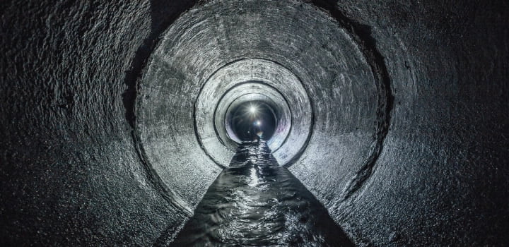The interior of a sewer drain with water flowing through it in Maidstone.